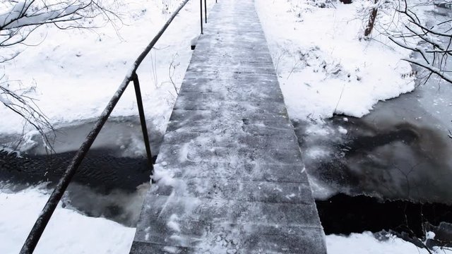 Pedestrian bridge over river. Winter snow landscape. Stock vedeo on go