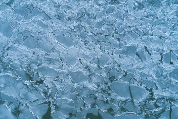 Aerial Top-Down View of Cracked, Broken, and Melting Ice on a Water Surface