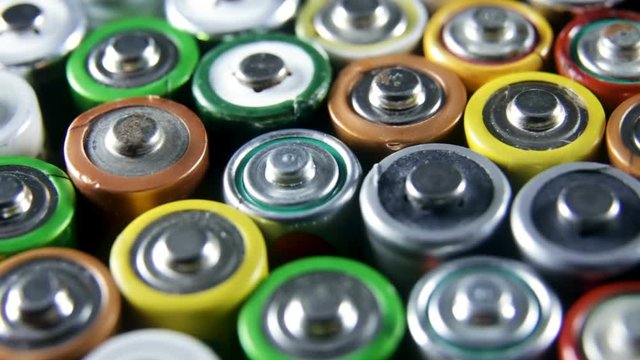 Collection of old used AAA batteries. High danger for the environment. Batteries background