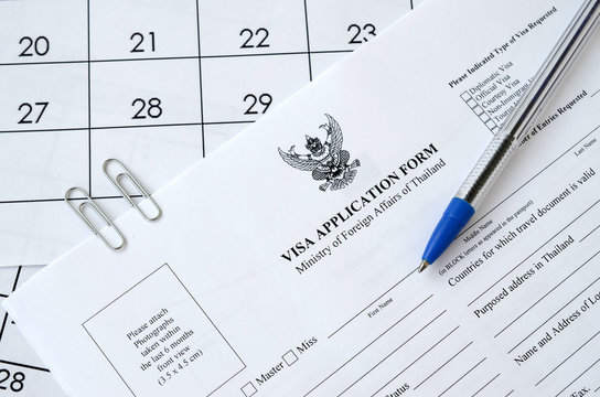 Thailand Visa application form and blue pen on paper calendar page