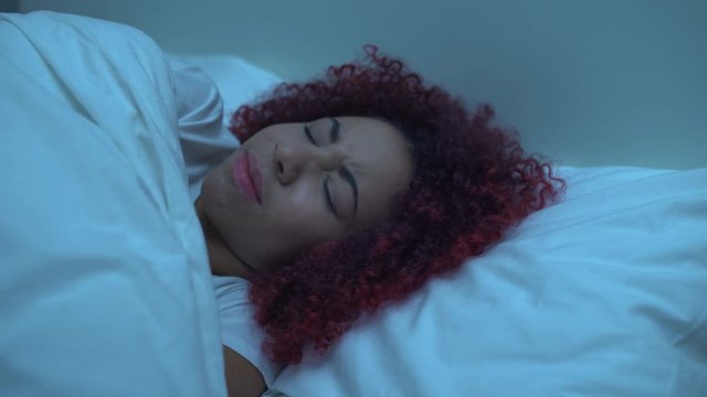 Scared african female waking up in bed, horrible nightmare, phobias, problems