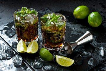 Cool  Cuba libre  in glasses on  dark table, holidays party concept