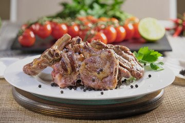 Grilled lamb with cherry tomatoes and spices on a vintage wooden table