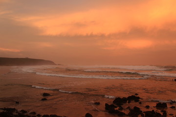 dramatic sunset on the beach with orange clouds