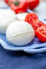 Cheese collection, fresh Italian soft mozzarella cheese in balls served with red ripe tomatoes