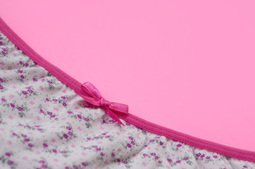 Ribbon on white women underwear with lace on pink background with copy space. Beauty fashion...