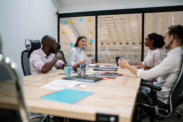 Excited employee discussing project with colleagues at workplace