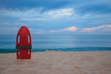 Isolated Lifeguard rescue can at the shore with the ocean at dawn as background