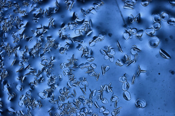 blue ice glass background, abstract texture of the surface of the ice on the glass, frozen seasonal water