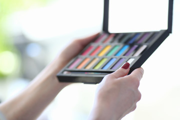 Makeup Artist Holding Beauty Cosmetic Product. Female Hands with Colorful Eye Shadow Palette Closeup. Woman Promote Maquillage Kit with Compact Mirror. Visagist Tools Shallow Focus
