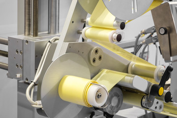 Fragment of the conveyor of sticking labeling machine. Abstract industrial background.