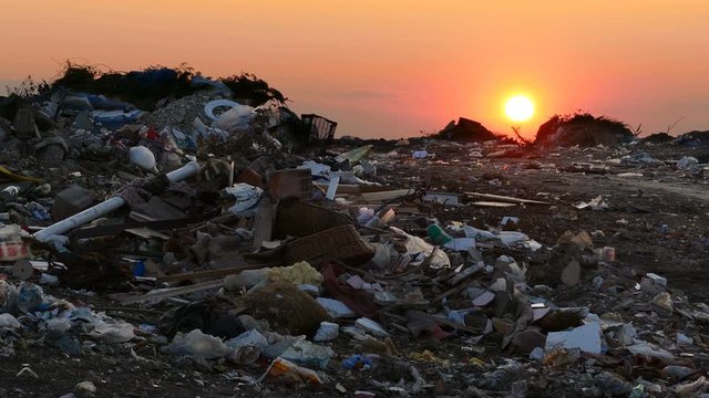 Garbage dump pollution at sunset, lots of plastic bags, environmental pollution landfill near the city. Contrast in the footage, ecological pollution on one side and beautiful sunset on the other