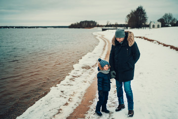 father and son standing together near the lake and talking