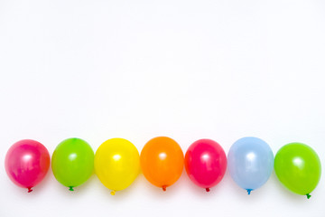 Fototapeta na wymiar Colorful balloons on white wall or table top view. Festive or party background. Flat lay style. Copyspace for text. Birthday greeting card