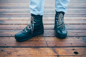 Close-up of female legs in jeans shod in rough boots