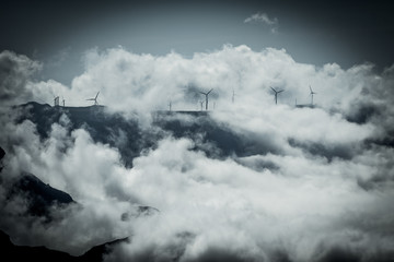 Wind power station installed on the mountain top with dramatic clouds