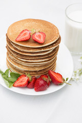 Homemade pancakes with fresh strawberries and honey.