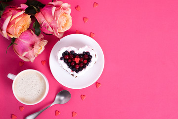 Heart shaped cake decorated with red currant on pink back