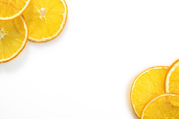 Slices of dry orange are laid out on white background. Dry fruit background with place for text