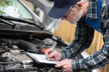 Car mechanic checking a car engine
