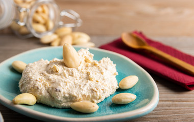 Fototapeta na wymiar Homemade organic vegan butter made from almonds on a wooden background.