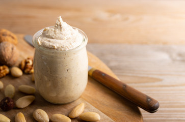 Homemade organic vegan butter made from almonds on a wooden background.