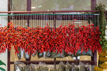 Red chili pepper chain hanging to dry in a market place