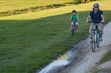 Naklejka premium Father and son cycling in the countryside