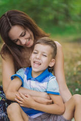 Vertical color photography of happy laughing and smiling european mother and little son playing...
