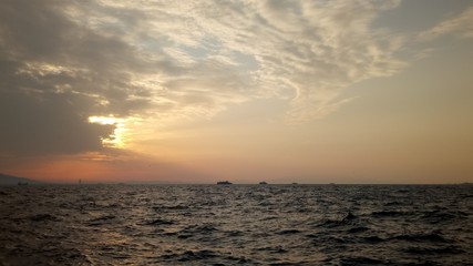 Por do sol coberto por nuvens na orla do mar egeu em Izmir- Turquia