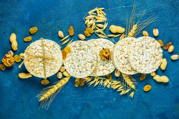 Color of 2020 year. Classic Blue, food trendy background. American puffed rice cakes. Healthy snacks with ears of wheat on classic blue concrete surface.