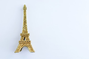 Golden shiny eiffel tower figurine on white background.