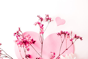 A large pink heart with a place for text decorated with small pink flowers on a white background