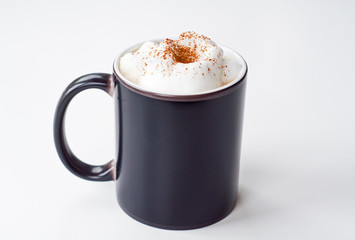 Black cup with milk foam and cinnamon