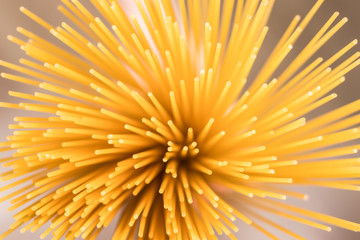 Raw spaghetti in hand, top-down view. Selective focus.