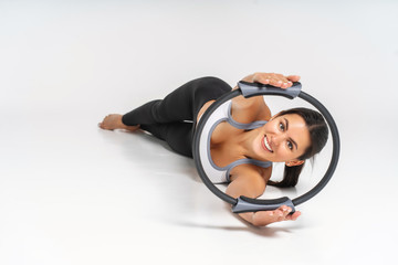 young woman doing exercise with pilates circle