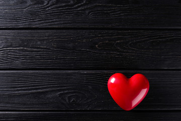 Red Heart shape on black wooden rustic background