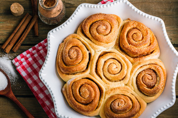 Sweet cinnamon rolls on a wooden table, homemade cakes