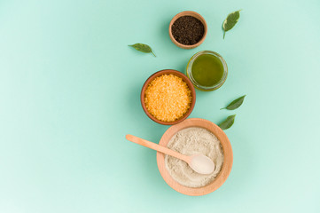 Cosmetic bath salt, grape gomaj for the face, coffee scrub for the body on a mint background. Spa...