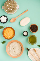Cosmetic bath salt, grape gomaj for the face, coffee scrub for the body on a mint background. Spa...