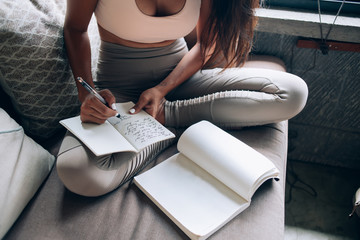 Female student sitting with book and writing