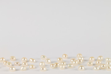 The light background with white pearls. Jewelry.