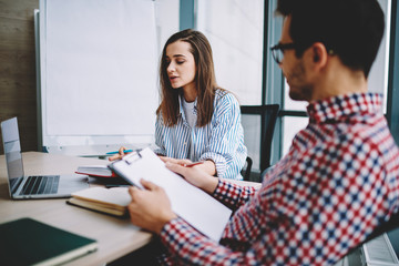 Fototapeta premium Male and female colleagues analyzing business plan together at office