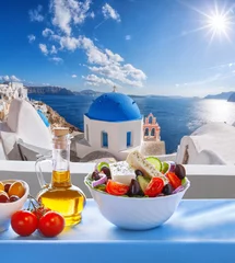 Foto op Plexiglas Greek salad against famous church in Oia village, Santorini island in Greece © Tomas Marek