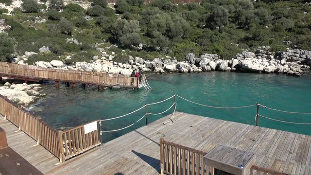 Andrea Doria Bay, Finike, Turkey - 10th of January 2020: 4K Several men fishing on the platform covered Andrea Doria bay