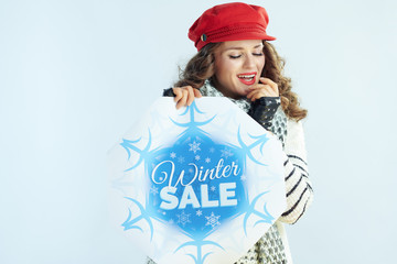 woman with winter sale banner warming hands with warm breathe