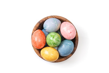 Different easter eggs in wooden bowl isolated on white