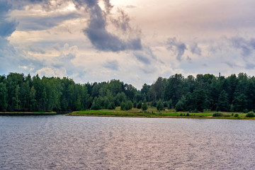 Sailing along the banks and islands of northwest rivers one early autumn day with grey sky and clouds