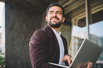Cheerful ethnic entrepreneur using laptop