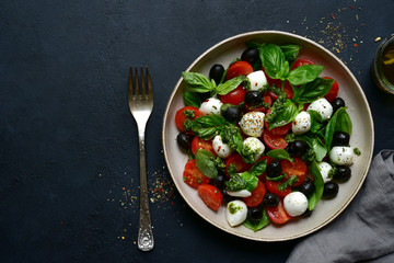 Caprese - traditional italian vegetable salad with mozzarella cheese. Top view with copy space.